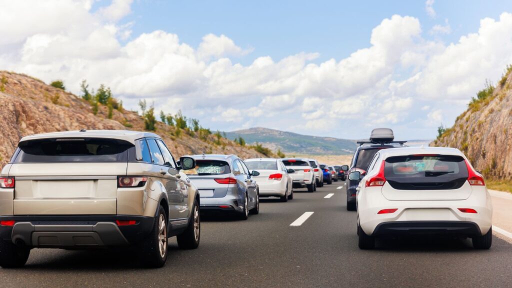 cars on a road with pavement markings down the middle separating lanes