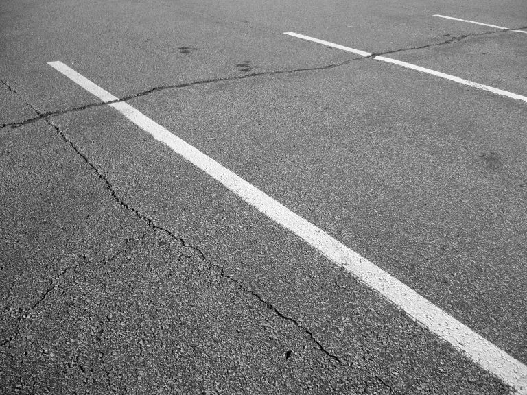 cracks in parking lot pavement, in need of parking lot maintenance
